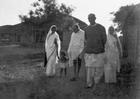 Téléchargez les photos : Rajkumari Amrit Kaur, Mahatma Gandhi, Mahadev Desai, Krishnadas Gandhis fils Sharad et d'autres marchant à l'Ashram de Sevagram, 1940 - en image libre de droit