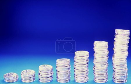 Growth from coins isolated on blue background