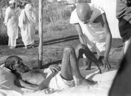 Foto de Mahatma Gandhi atendiendo al leproso paciente estudioso sánscrito Parchure Shastri en el Ashram Sevagram, 1939 - Imagen libre de derechos