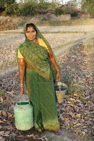 Téléchargez les photos : Femme rurale portant des pots d'eau ; Chitrakoot ; Uttar Pradesh ; Inde - en image libre de droit