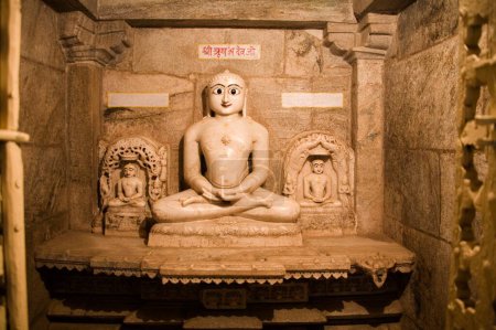Téléchargez les photos : Trois idoles de Teerathnkar Shri Rishabh devji au centre et Shri Dada Guruji (gauche et droite) dans la posture yogique du padmasan de méditation dhyan ; monument antique vieux de 2000 ans temple Adinath Jain ; Village Delwara ; Udaipur ; Rajasthan ; Inde - en image libre de droit