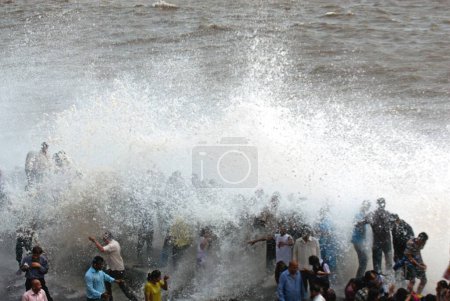 Photo for People enjoying hightide waves at marine drive ; Bombay Mumbai ; Maharashtra ; India  24-July-2009 - Royalty Free Image