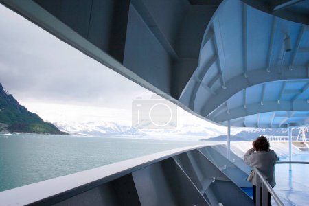 Foto de Una dama observando desde un crucero un glaciar Hubbard; El glaciar de marea más largo de Alaska; Parque Nacional Saint Elias; Bahía de desencanto; Alaska; Estados Unidos de América - Imagen libre de derechos