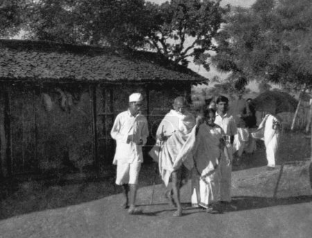 Téléchargez les photos : Mahatma Gandhi et d'autres marchant à l'Ashram de Sevagram, 1939 - en image libre de droit