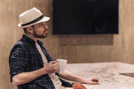 Employee having coffee sitting in the office break room thinking about his tasks. Lifestyle concept.