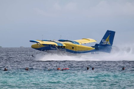 Foto de Atolón Lhaviyani, Maldivas, 12 de diciembre de 2014: La gente está buceando en el océano, con un hidroavión moviéndose justo detrás de ellos. - Imagen libre de derechos