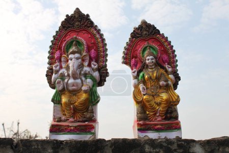 Photo for Agra, Uttar Pradesh, March 11, 2019: India- Two colorful Hindu deity statues of Shiva and Ganesh standing on a wall in Agra, India with sky in the background - Royalty Free Image