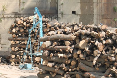 Stacks of firewood prepared for cremation ceromonies near Marnikarnika Ghat in Varanasi, one of the holiest grounds among the riverfronts on river Ganges. An old blue scale stands midst all the logs