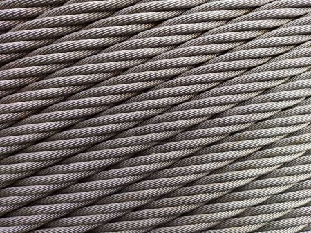 Grey Steelcable, macro shot, horizontal for Background and Industry. Wire rope is composed of two solid, metal wires twisted into a helix that forms a composite rope, in a pattern known as laid rope