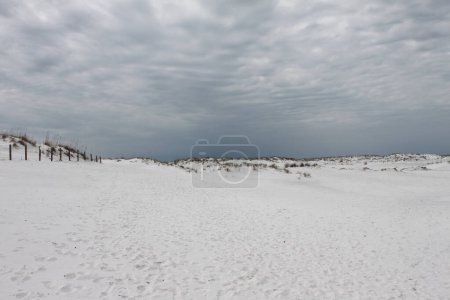 Sanddünen am Eglin Matterhorn Beach in Destin, Florida, USA. Malerische, leere Landschaft in Florida Panhandle. Feiner, weißer Sand. Natürlicher Zugang zum Strand am Golf von Mexiko. Endloser Sand und dramatischer grauer Himmel treffen sich am Horizont