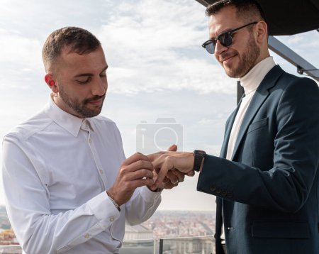 Homosexuales casándose al aire libre, en una terraza de Madrid con vistas a la ciudad, después de la ceremonia civil. Se pusieron su anillo de bodas..
