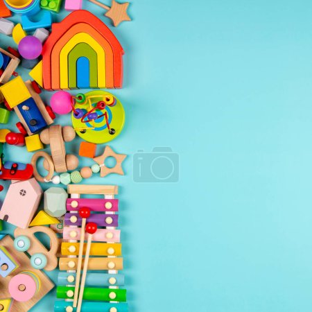 Baby kids toys on light blue background. Colorful educational wooden and musical toys. Top view, flat lay.
