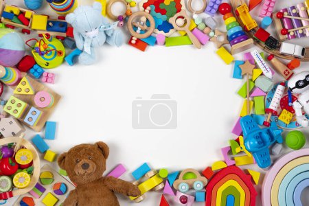 Rama dziecięcych zabawek. Zestaw barwnych edukacyjnych zabawek drewnianych, plastikowych i puszystych na białym tle. Widok z góry, płaski.