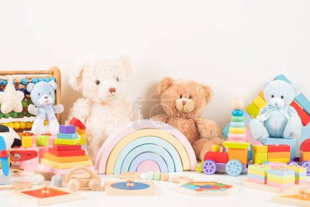 Pädagogische Sammlung von Kinderspielzeug. Teddybär, Holzflugzeug, Eisenbahn, Abakus, Regenbogen, hölzernes pädagogisches Babyspielzeug auf weißem Hintergrund. Nachhaltiges, umweltfreundliches Spielzeug. Frontansicht.
