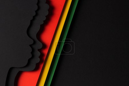 Photo for Black History Month color background. African Americans history celebration. Abstract geometric red, yellow, green color background with black paper cut people silhouette. Top view. - Royalty Free Image