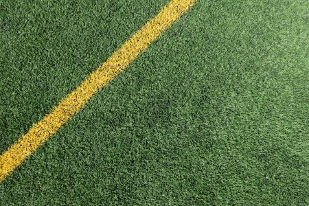 Photo for Green artificial grass turf soccer football field background with yellow line boundary. Top view - Royalty Free Image