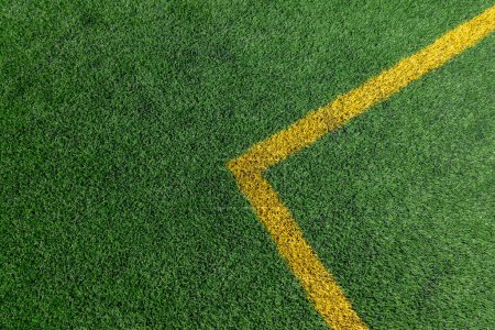 Photo for Green artificial grass turf soccer football field background with yellow line boundary. Top view - Royalty Free Image