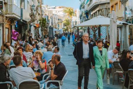 Photo for Benidorm, Spain - 01 April, 2023: People in crowdy streets of Benidorm old town. People relaxing in outdoors cafes. Benidorm - popular Spanish resort near Mediterranean sea. - Royalty Free Image