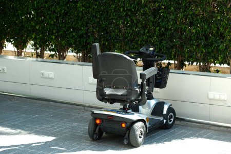 Photo for Benidorm, Spain - May 01, 2023: Four wheel mobility electric scooter charging up. Personal transport for seniors or people with disability. - Royalty Free Image
