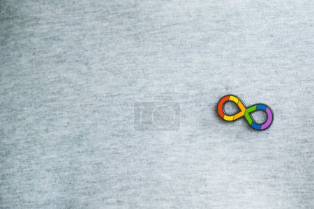 Photo for Teenage boy with autism infinity rainbow symbol sign metallic pin brooch on t-shirt. World autism awareness day, autism rights movement, neurodiversity, autistic acceptance movement. - Royalty Free Image