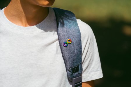 Photo for Adolescent boy with backpack with autism infinity rainbow symbol sign. World autism awareness day, autism rights movement, neurodiversity, autistic acceptance movement. - Royalty Free Image