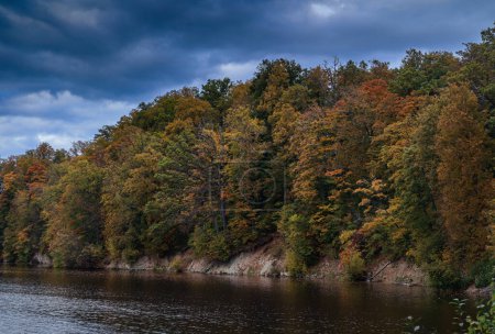 Une promenade le long de la rivière un jour d'automne.Les feuilles des arbres sont peintes en jaune, rouge et orange. La rivière est calme et paisible.