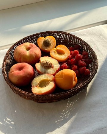 Früchte in einem Weidenkorb auf dem Tisch. Ästhetik von Sommerfrüchten und Beeren