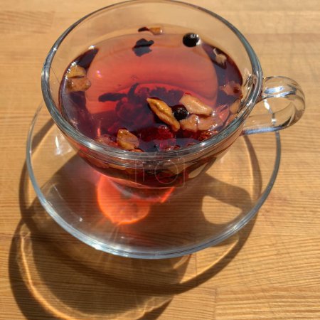 A cup of berry tea on a wooden table