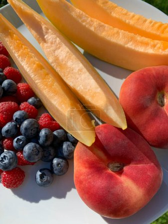 Helle Sommerfrüchte und Beeren auf einem Teller an einem sonnigen Tag