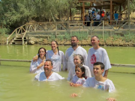 Téléchargez les photos : Yericho, Israël - 18 août. 2012 : Chrétiens religieux vêtus de vêtements blancs dans l'eau du Jourdain sur le site baptismal Qasr el Yahud près de Yericho - en image libre de droit