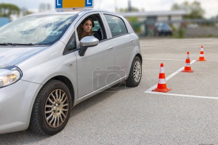 Teenager Mädchen parkt ihr Auto auf dem Polygon zwischen den Zapfen .