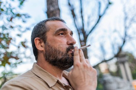 Portrait of a Mid Adult Man with Beard Smoking a Cigarette on the Street