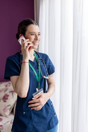 Young woman  doctor talking on the phone and smiling.