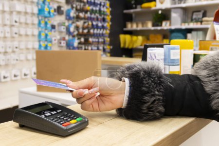 Frau bezahlt im Geschäft mit Kreditkarte