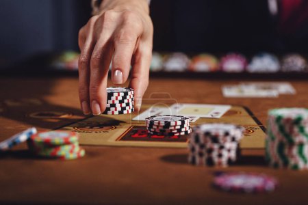 Photo for Poker table with cards and chips, the croupiers hands hold, shuffles, cards, the croupier gives out a win - Royalty Free Image