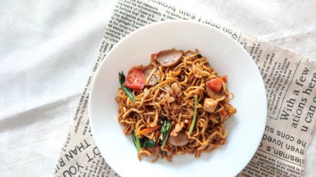 noodles with vegetables and sausage with on white plate