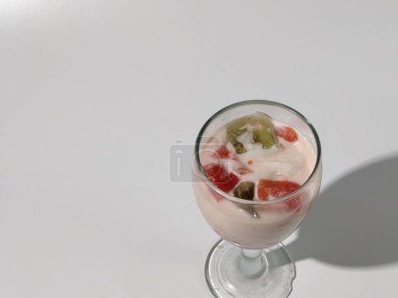 Téléchargez les photos : Sop buah ou es campur dans une tasse en verre sur un fond blanc. Restauration rapide de rue. Populaire dessert aux fruits indonésien - en image libre de droit