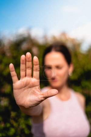 Photo for Firm woman expressing the action of enough with her hand, no or stop, no violence, no permission, no, it is no - Royalty Free Image