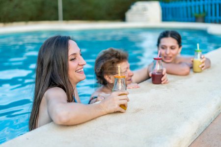 Photo for Beautiful and happy women of different ages having fun by the pool while drinking healthy beverages - Royalty Free Image