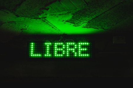 Photo for Illuminated green traffic sign for free parking in indoor parking - Royalty Free Image