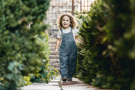 Téléchargez les photos : Portrait de heureux petit garçon et modèle, promenade dans le jardin médiéval de la ville, visite guidée - en image libre de droit