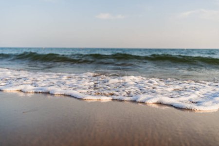Foto de Primer plano de suave ola de mar agradable en la orilla con la luz del atardecer - Imagen libre de derechos