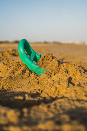 Photo for Small children toy buried after playing with it in the beach sand - Royalty Free Image