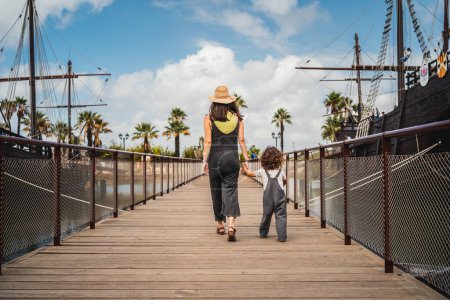 Foto de Mujer y hijo moderno, hermoso y feliz haciendo turismo en un parque temático, en Muelle de las Calaberas, Huelva - Imagen libre de derechos