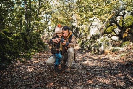 Photo for Photographer father and fashionable son happy learning to take photographs in a beautiful natural environment - Royalty Free Image