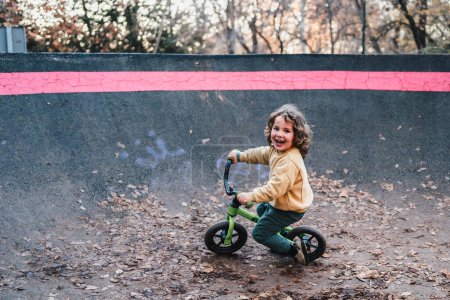 Photo for Happy fashionable little boy training with his bicycle on urban pump track circuit - Royalty Free Image