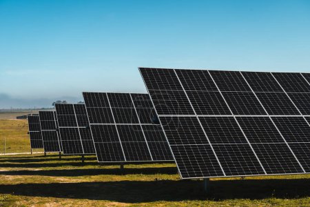 Foto de Conjunto de paneles solares bajo cielo azul, en planta solar fotovoltaica, día soleado brillante - Imagen libre de derechos