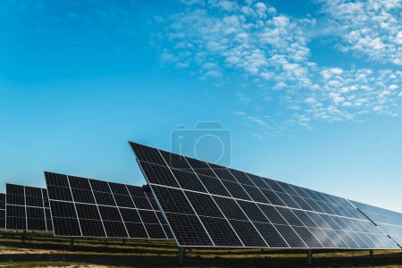 Foto de Conjunto de filas de paneles solares bajo el cielo azul, en planta solar fotovoltaica, día soleado brillante - Imagen libre de derechos