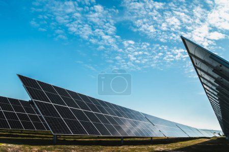 Foto de Línea de paneles solares en planta solar fotovoltaica, día soleado brillante - Imagen libre de derechos