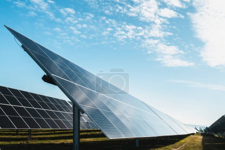Foto de Conjunto de paneles solares en el parque solar fotovoltaico, día soleado brillante con cielo azul y algunas nubes - Imagen libre de derechos